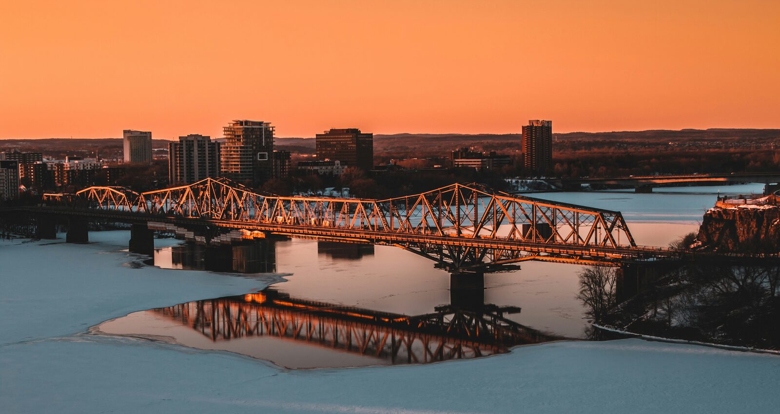 Platzhalter-Foto — Symbolbild: Alexandra Bridge in Ottawa, hier winterlich mit Eis auf dem Fluss — im Oktober wird das Ufer nicht zugefroren sein